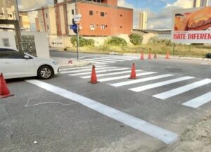 Agentes da Semob-JP realizando pintura de sinalização viária em rua de João Pessoa.